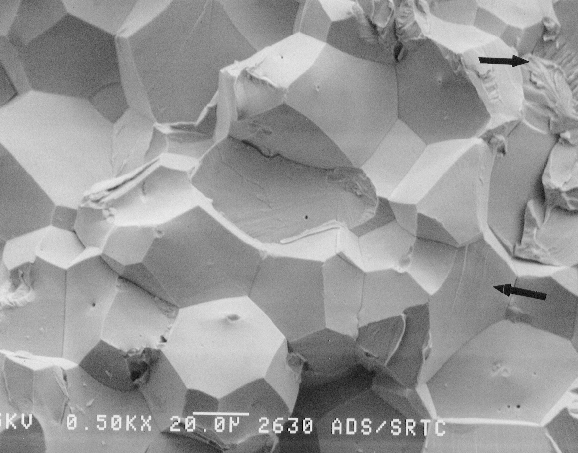 Figure 9b. SEM photographs of the fracture surface of the drain valve tip. Nickel was not observed in the center (near drain valve tip) of the fracture surface. Arrows indicate regions of cleavage fracture.