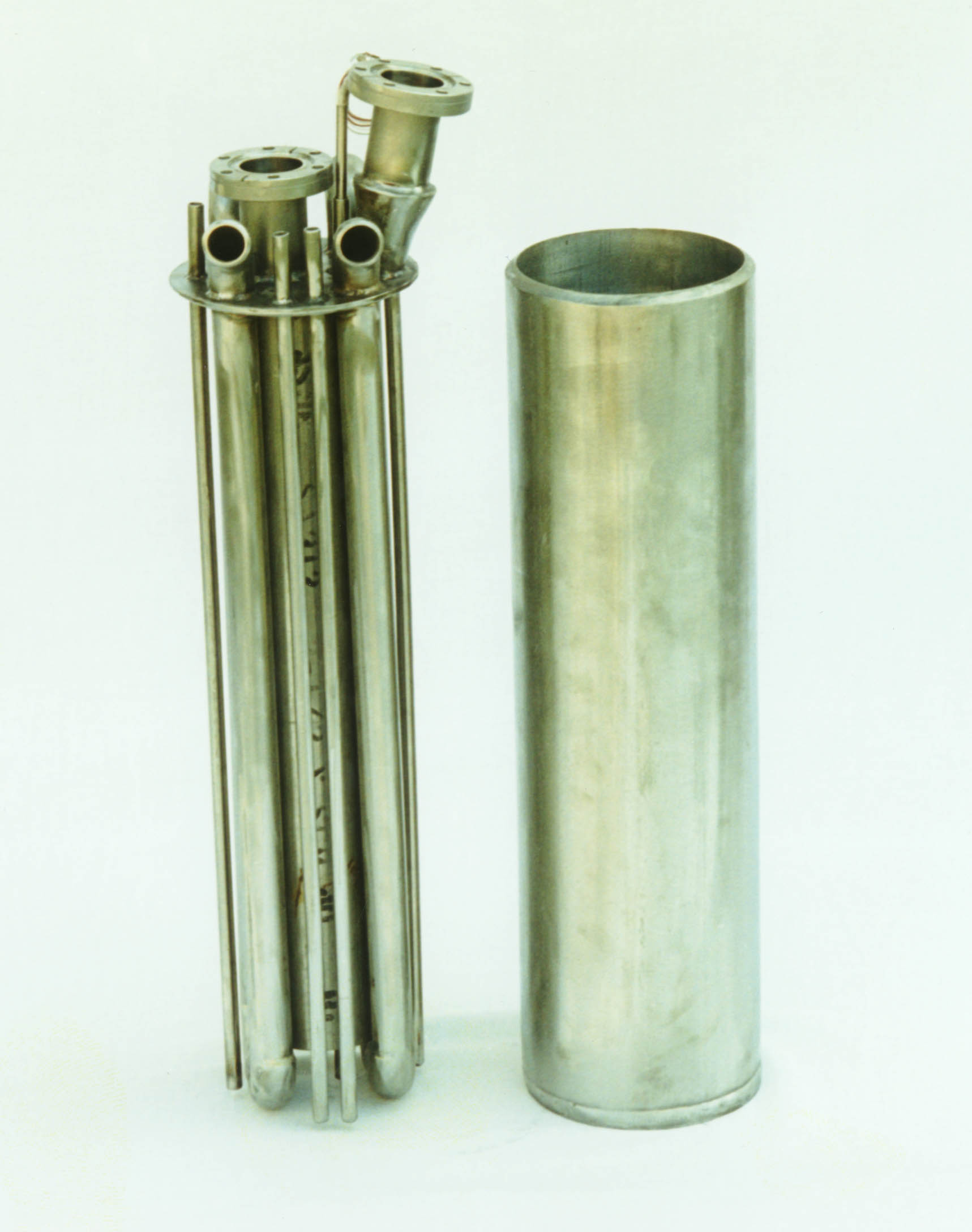 Figure 5. Photograph of the side view of the flow through bed prior to filling with Pd/k material and final assembly. After filling with Pd/k, the center pipe bundle is placed in the can and welded around the spacer. The taller flanged connection is the feed gas inlet to the annulus; the shorter flanged connection is exit gas outlet from the center pipe. Note flat end caps.