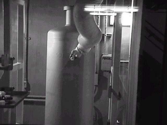 Figure 1: A Manipulator Arm Holds a Smear on a Stainless Steel Canister Filled
with High Level Waste in the Smear Test Station at the Defense Waste Processing
Facility